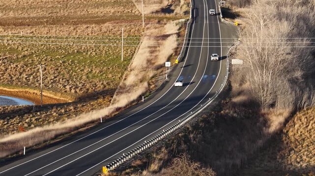 Vehicles Driving on Rural Highway Through Australian Countryside