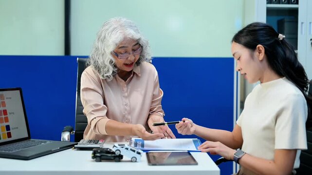 Car insurance consultation using smartphone and documents. Advisor and customer reviewing digital insurance service, auto policy, finance