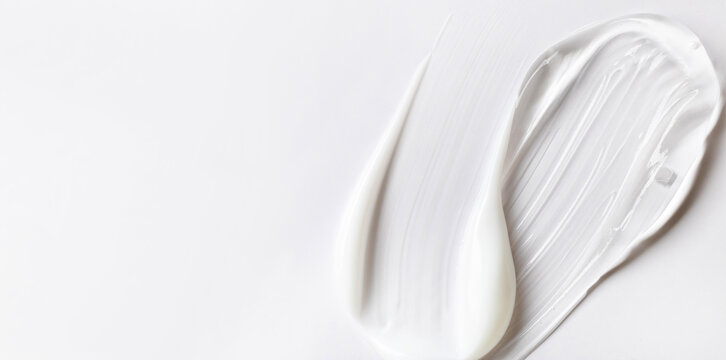 samples of cosmetic care products smear of cream and gel texture on a light background