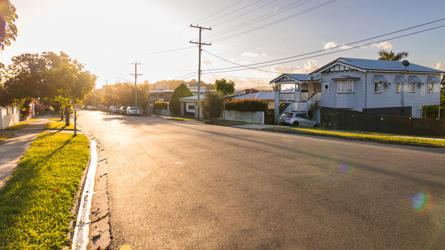 a quiet suburban street at sunset with golden light