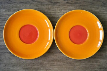 Orange plate on wooden surface, minimal rustic style