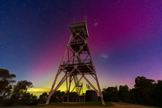 Metal observation tower standing tall against a vivid night sky
