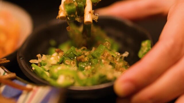 Chopsticks Picking Up Japanese Okra Salad with Bonito Flakes