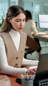 Business, woman and document in office with laptop, research and review payroll for accounting. Person, coworking and paperwork at company with tech, finance report and statement for monthly turnover