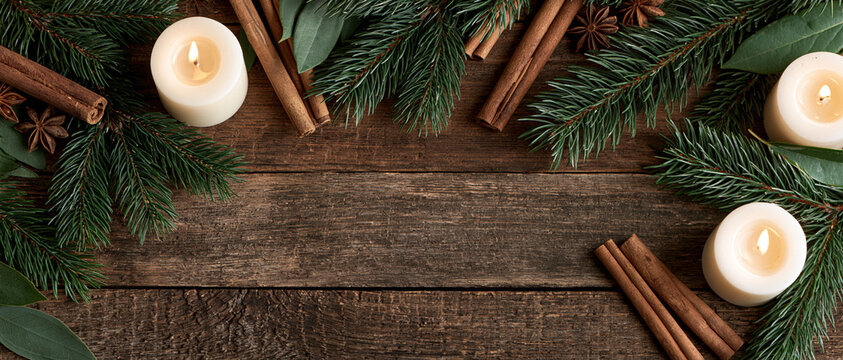Cozy Christmas Flat Lay with Evergreen Branches Cinnamon Sticks and Candles on Wood
