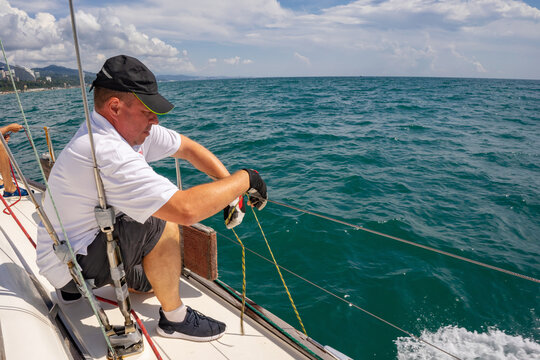 Man attaches fenders to a yacht before it enters the harbor