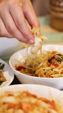 Person Eating Thai Papaya Salad and Sticky Rice by Hand