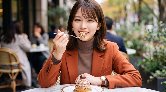 カフェのテラス席でモンブランケーキを美味しく食べる女性（秋のスイーツ・ご褒美・カフェ巡り）
