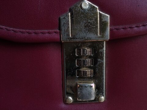 Close-up of a Combination Lock on a Burgundy Leather Bag.