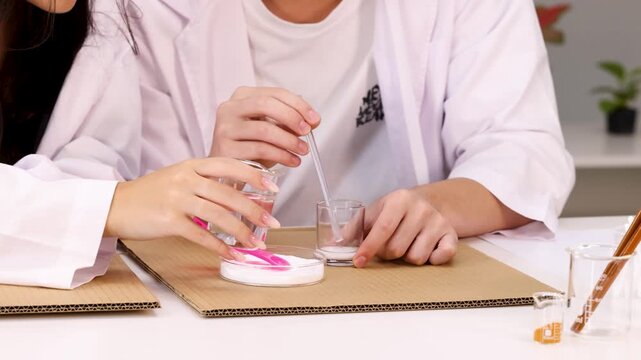 Students in Lab Coats Mixing Chemicals During Science Experiment
