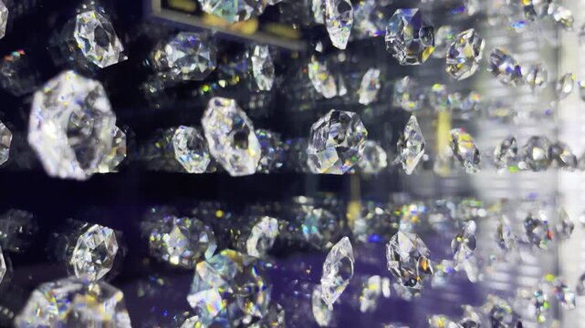 Camera glides beside rows of faceted chandelier crystals reflecting light
