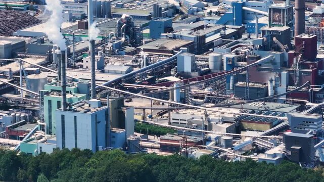 High angle view of the large Lenzing industrial complex. Smokestacks release plumes of smoke and steam into the air from the facility