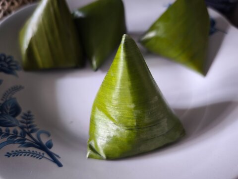 Traditional steamed rice cakes wrapped in fresh green banana leaves