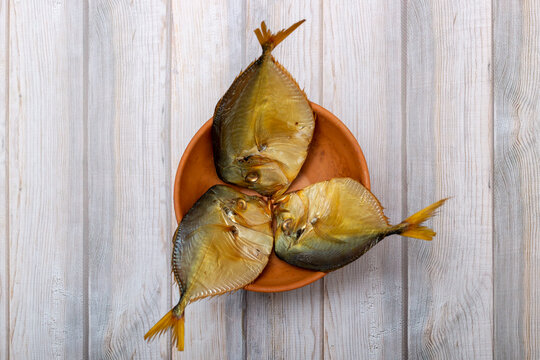 Three smoked sea fish close-up in a plate