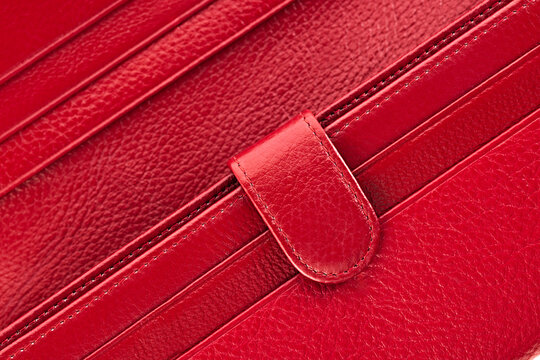 Macro close up of genuine red leather wallet texture stitching and card slots