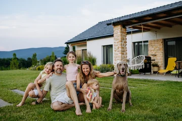 Parents and daughters enjoying late summer together outside family home. © Halfpoint