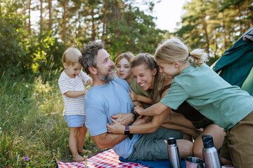 Naklejka premium Happy family spending time together during summer camping trip.