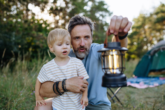 Father and children enjoying outdoor family vacation at campsite.