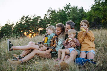 Naklejka premium Family hiking together through countryside during summer camping trip.
