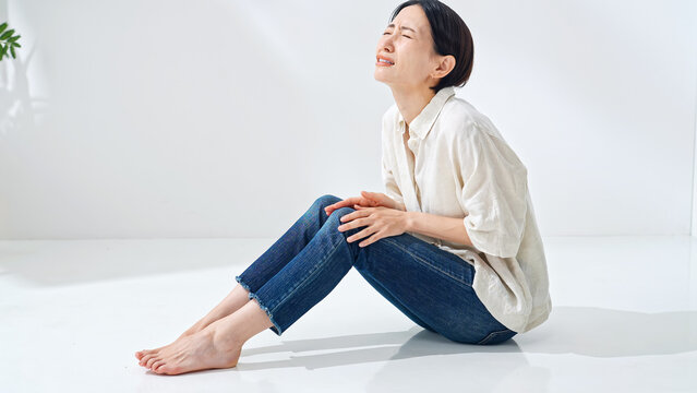 ひざが痛む女性。膝痛、関節痛、痛み、リウマチ、痛風、疲れ、疲労、老化、加齢、軟骨、炎症、半月板、靭帯