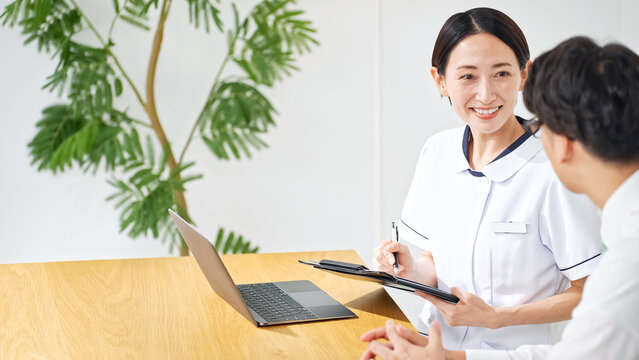 問診する白衣の女性。看護師、医師、産業医、相談、面談、診察、診療、健診、受付、クリニック、薬剤師