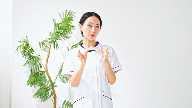 会話する白衣の女性。看護師、介護士、インタビュー、診察、診療、相談、面談、問診、取材、説明、医療事務