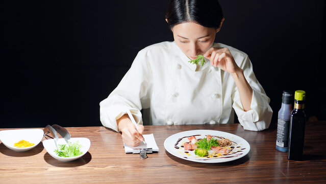 レシピを考える女性シェフ。調理師、レストラン、飲食店、料理、フレンチ、イタリアン、メモ、ディナー