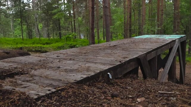 Handmade wooden ramp for extreme sports like motocross and mountain biking standing in the middle of a beautiful pine forest, ready for jumps, tricks, and freestyle practice
