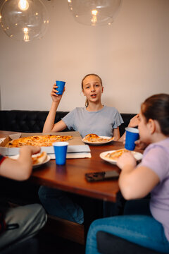 Young girl talking with friends at pizza party