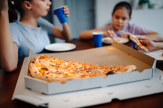 Family enjoying pizza dinner at home together