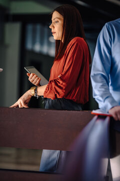 Businesswoman talking in office holding tablet
