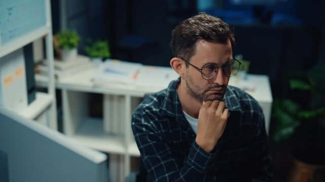 Young Caucasian male programmer write code on computer in home office at late night. AI technology, cybersecurity, software developer, freelance innovation, database system, digital network concept.