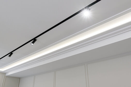 minimalist ceiling features black magnetic track lighting system with adjustable spotlights clean LED strip recessed into elegant white crown molding