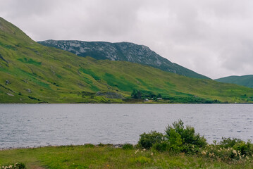 Fototapeta premium Twelve Bens mountain range, a rugged chain of peaks rising above the scenic Connemara landscape in western Ireland - County Galway, Ireland - 31 August 2026.