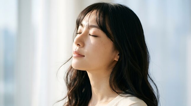Woman with closed eyes experiencing peaceful moment by bright window person female hair face eye nose mouth.