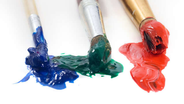 Colorful paint on brushes placed on a white background during an art activity