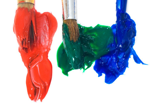 Different colors of paint on brushes with red, green, and blue hues