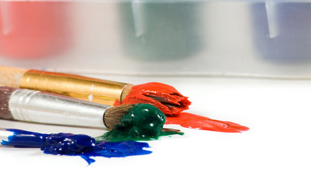 Art supplies laid out with paint and brushes on a surface in a studio setting