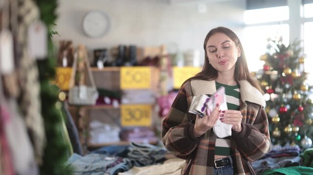 Glad young lady looking for convenient socks in retail outlet during X-mas sell-out 