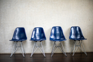 Naklejka premium Four blue chairs aligned neatly.