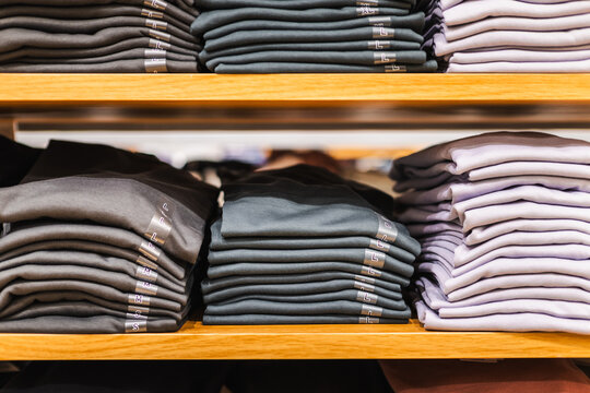 Neatly Folded Shirts on Wooden Retail Shelves