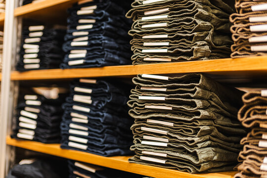 Neatly Folded Pants Stacked on Wooden Store Shelves