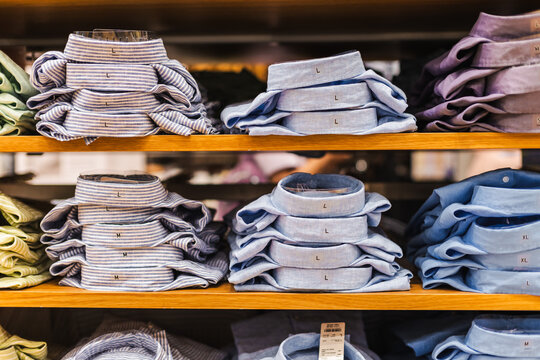 Neatly Folded Shirts on Wooden Retail Shelves