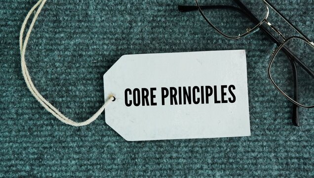 Glasses and paper tags with the words Core Principles. the basic rules and core values ​​that guide how people and organizations make choices and act.