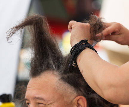 Hand styles wild hair in a playful, upward fashion