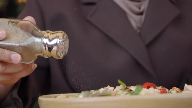 Adding salt to a fresh salad in a restaurant