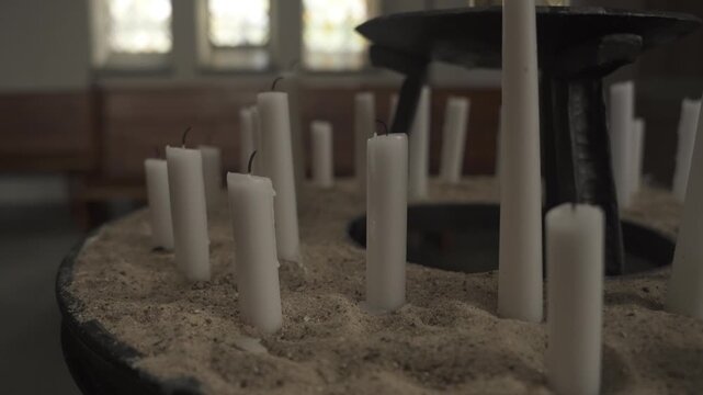 Rows of White Candles in Sand Close Up Church Interior Memorial