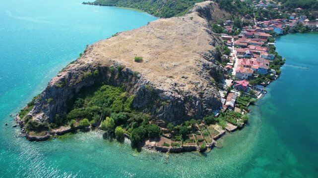 Lin village peninsula on rocky shore of quiet lake with emerald water in Albania