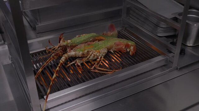 Two split spiny lobsters cook over bright flames on a commercial restaurant grill.