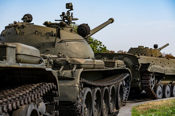 Naklejka premium Vintage soviet military tanks and armored vehicles on display outdoors. Closeup of green heavy combat vehicles including old battle tanks in row under clear sky